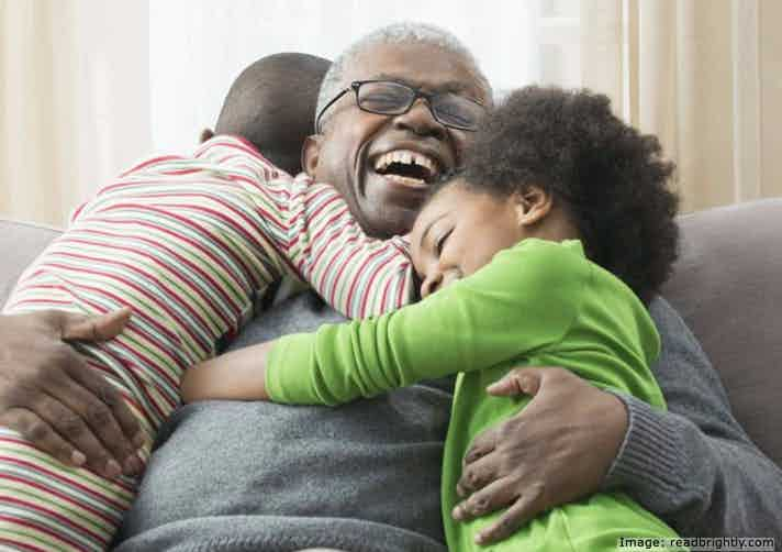 Happy, laughing grandfather, hugging boy and girl